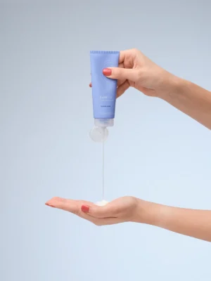 Activating Cleanser wird aus der Tube in die Handfläche gegeben